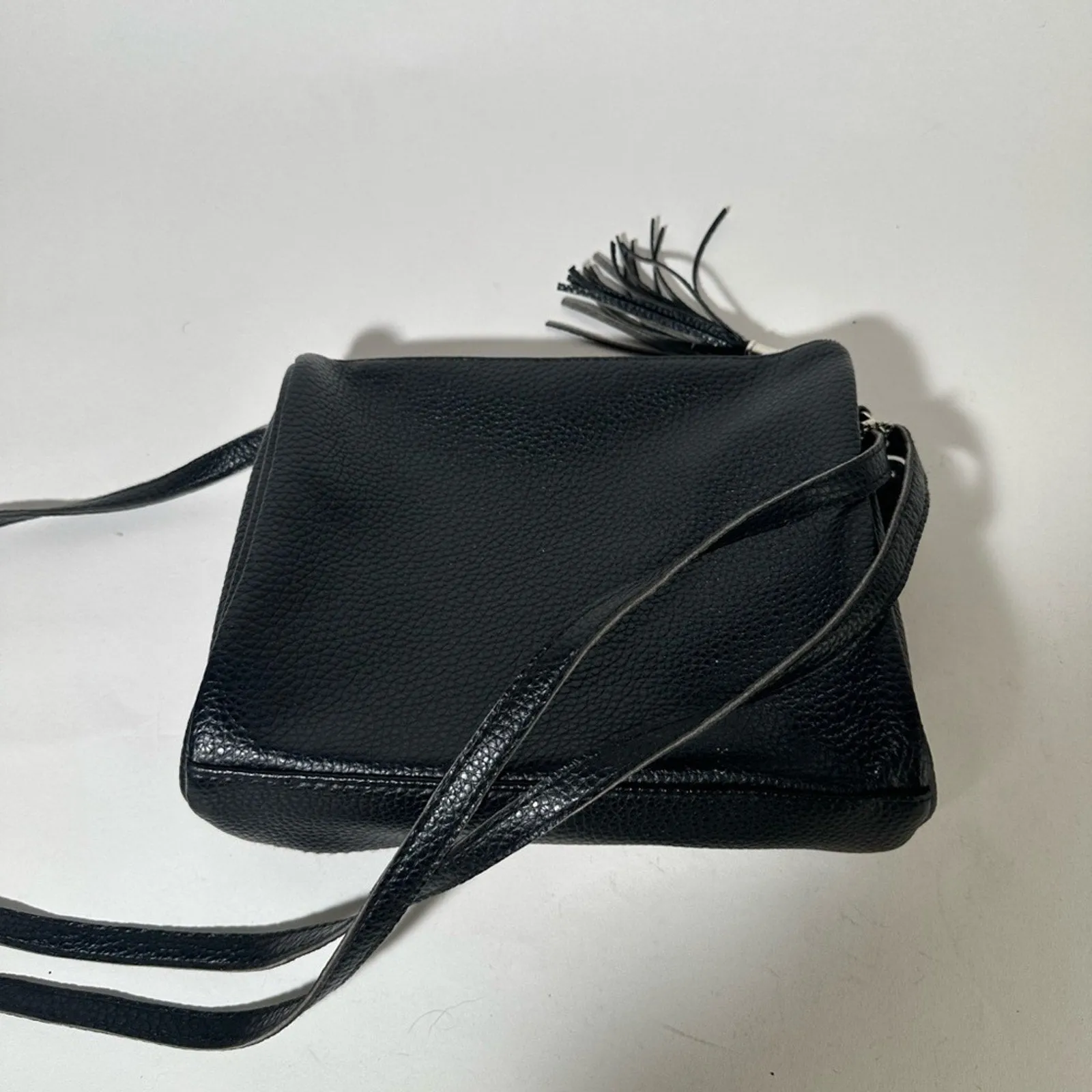 Sleek Black Crossbody Bag with Adjustable Strap and Tassel